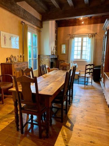 une salle à manger avec une grande table et des chaises en bois dans l'établissement Le Refuge Cathédrale - Le Puy-en-Velay, au Puy-en-Velay