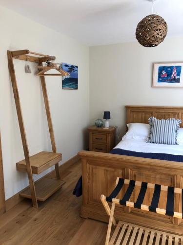 a bedroom with a bed and a wooden floor at Little Grey Barn in Pagham
