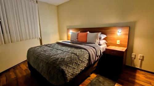 a bedroom with a large bed with a wooden headboard at Departamento céntrico y amoblado La Paz in La Paz