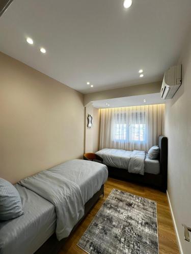 una camera da letto con due letti e un tappeto di Ideal Apartment Shkoder a Shkodër