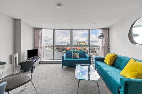 a living room with a blue couch and a large window at Skyline Belfast in Belfast