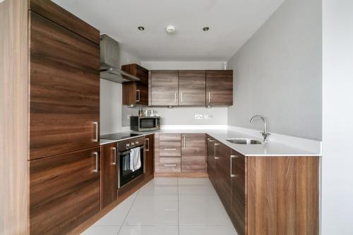 a kitchen with wooden cabinets and a sink at Skyline Belfast in Belfast