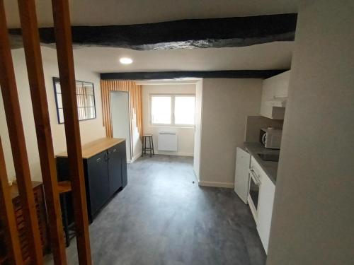 une pièce vide avec une cuisine et une fenêtre dans l'établissement Le SPArt un jacuzzi une salle de sport un appartement entièrement équipée pour votre bien être, à Paulhac