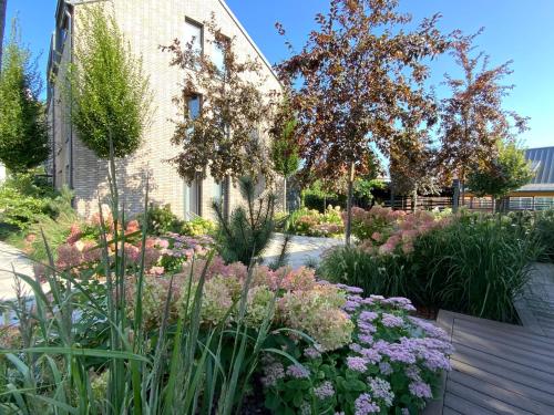 a garden with flowers in front of a building at Salt Garden Superior double rooms in Druskininkai