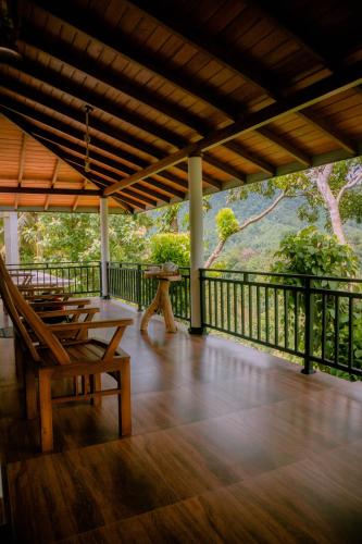 a porch with a table and chairs on a balcony at Evergreen Villa - Sinharaja in Deniyaya