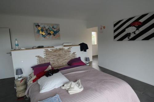 une chambre avec un grand lit avec un mur de briques dans l'établissement Villa ALPANNA, à Cirendinu