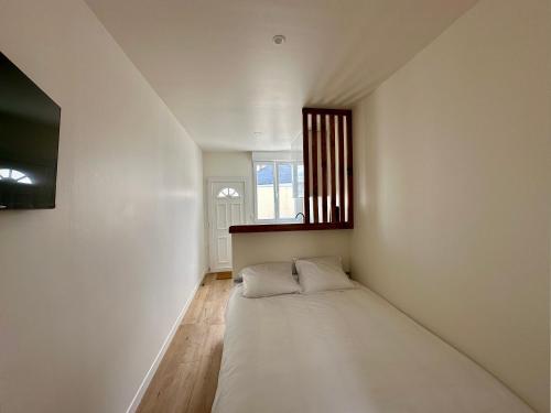 un petit lit dans une chambre avec une fenêtre dans l'établissement Charmant Studio à Saint Léonard, à Angers