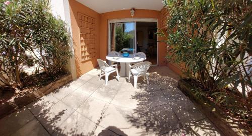 un patio avec une table et des chaises sur un patio dans l'établissement Studio climatisé 2 personnes avec terrasse et piscine, à Sainte-Maxime