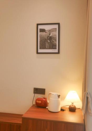 a table with a lamp and a picture on the wall at Kashgar QIu Ge Homestay in Kashgar