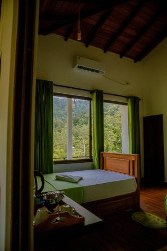 a bedroom with a bed and a window and a sink at Evergreen Villa - Sinharaja in Deniyaya