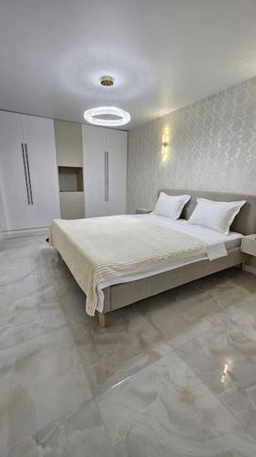 a bedroom with a large bed with white sheets and pillows at Квартира в Бендерах VIP in Bender