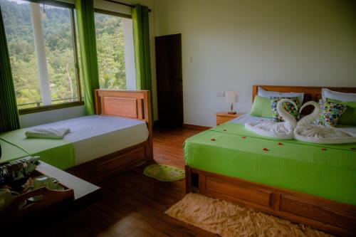 a bedroom with two beds and a window at Evergreen Villa - Sinharaja in Deniyaya