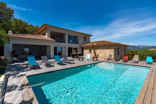 une piscine avec des chaises et une maison dans l'établissement Villa ALPANNA, à Cirendinu