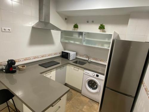 a small kitchen with a washer and dryer in it at Loft Madueño de los Aires in Alcalá de Guadaira