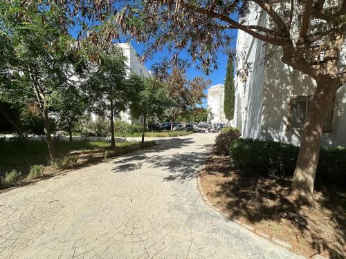 a street with a tree next to a building at Forest near to the beach قرب المستشفى الجامعي طنجة in Daidatz