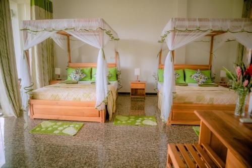 a bedroom with two beds with green pillows at Evergreen Villa - Sinharaja in Deniyaya