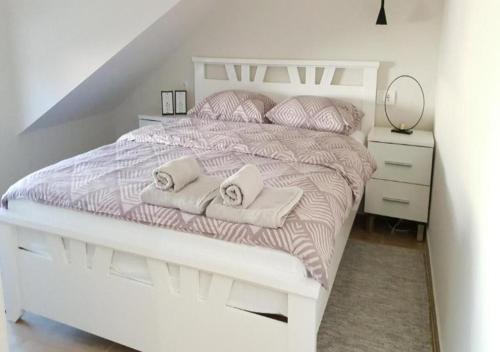 a bedroom with a white bed with two towels on it at Lovely Apartments Free STREET Parking in Novi Sad