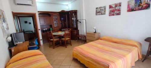 a bedroom with two beds and a table and a kitchen at Appartamento Rialdoli in Scandicci