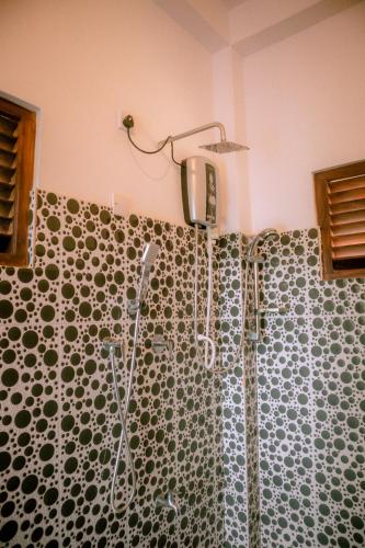 a shower in a bathroom with a patterned shower curtain at Evergreen Villa - Sinharaja in Deniyaya