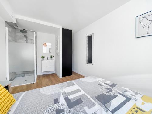a white room with a bed and a mirror at Échappée Douce à Hayange in Hayange