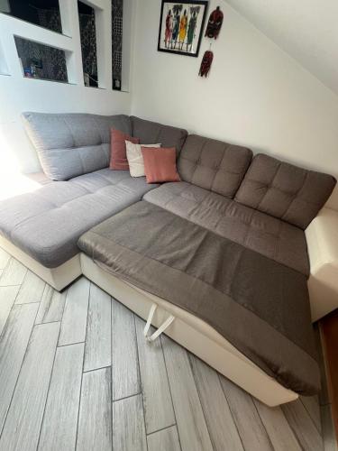 a large couch in a living room with wooden floors at La finestra su Torino in Orbassano