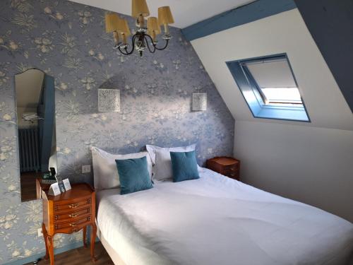 a bedroom with a large white bed with blue walls at Hotel de Charme La Bonne Adresse - Logis hotels in Le Havre