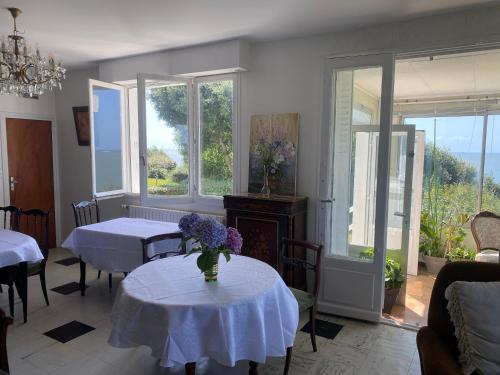 - un salon avec deux tables et deux fenêtres dans l'établissement Maison face mer !, à Pornichet