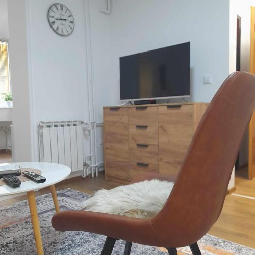 a living room with a chair and a table and a tv at Villa Sabic in Sarajevo