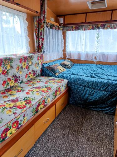 - une chambre avec 2 lits dans un coin salon dans l'établissement Caravane Vintage insolite avec jacuzzi au calme, à Sauvessanges