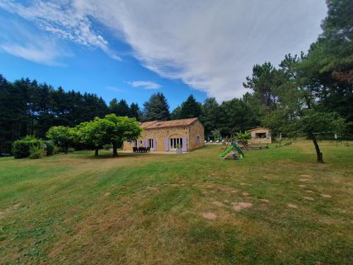 a house in the middle of a field with a playground at Maison de campagne - 5 chambres in Capdrot