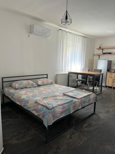 a bedroom with a bed and a table with chairs at Bellas apartmani in Novi Sad