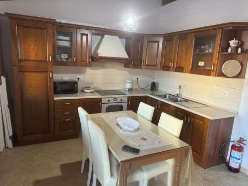 a kitchen with wooden cabinets and a table with chairs at Costa gentile in Càbras