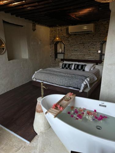 a bedroom with a bed and a bath tub and a bath tub at نزل حارة المسفاة Harit AL Misfah Inn in Misfāh