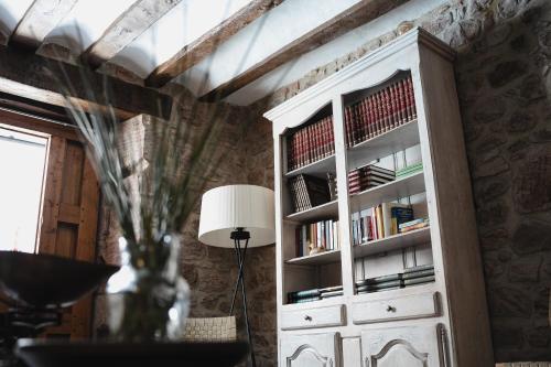 a room with a white cabinet with books at Hotel Rural LATORRIÉN DE ANE in Mues