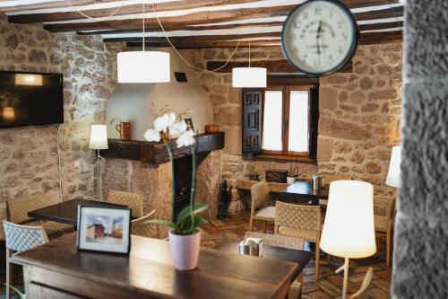 a room with a table and a clock on the wall at Hotel Rural LATORRIÉN DE ANE in Mues