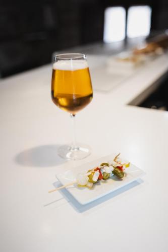 a glass of beer and a plate of flowers at Hotel Rural LATORRIÉN DE ANE in Mues