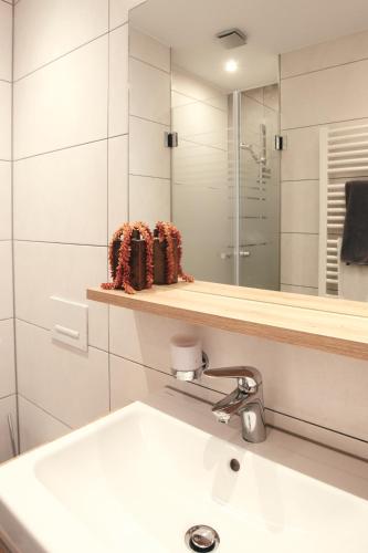 a white bathroom with a sink and a mirror at Hotel Restaurant Doppeladler in Rees
