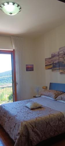 a bedroom with a large bed and a window at Appartamento Panoramico in Montepulciano