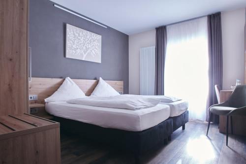 a bedroom with a large bed with white pillows at Hotel Restaurant Doppeladler in Rees