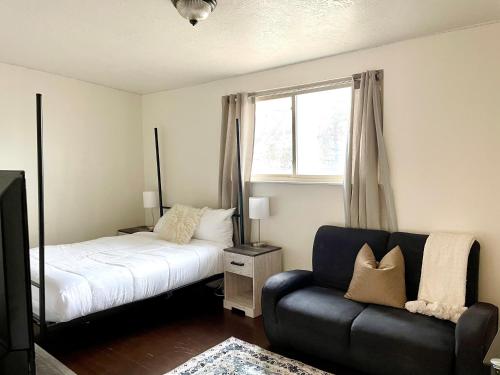 Un dormitorio con una cama y un sofá y una ventana. en Retreat, en Salt Lake City
