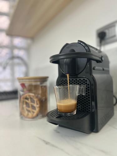 a coffee maker is making a cup of coffee at TEZONE SEVEN Apartments in Verona