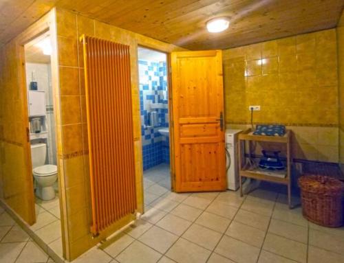 bagno con servizi igienici e porta in legno di Caravane Vintage Atypique avec jacuzzi à la campagne a Sauvessanges