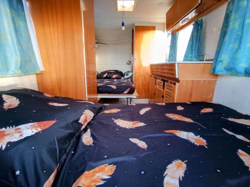 una camera da letto con un letto con degli aquiloni sopra di Caravane Vintage Atypique avec jacuzzi à la campagne a Sauvessanges