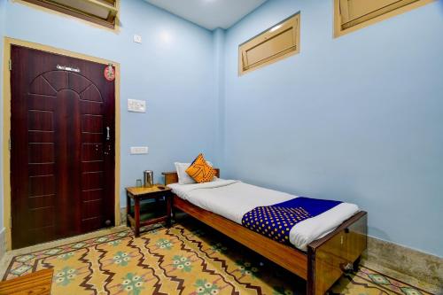 a bedroom with a bed and a wooden door at Hotel O Gajraj in Guwahati