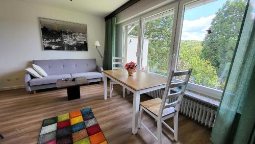 a living room with a couch and a table and a window at Haus Traudel in Overath