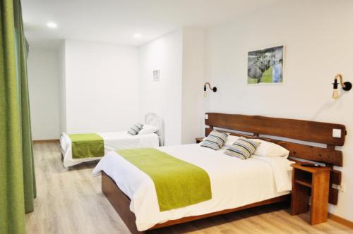 two beds in a room with green curtains at Apartamento Equitare Rural na Serra de Lousã in Miranda do Corvo
