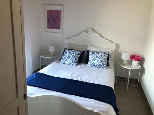a bed with blue and white sheets and pillows at Casa do Carpinteiro in Monte Claro