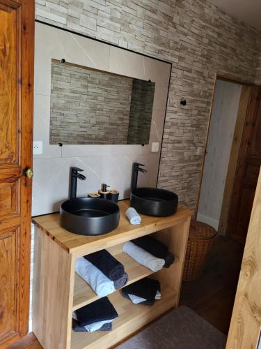 - une salle de bains avec deux lavabos sur une étagère en bois dans l'établissement Reposant et Dépaysant, à Lassur