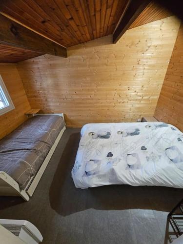 a bedroom with a bed in a wooden room at la chêneraie appart Hérisson in Ychoux
