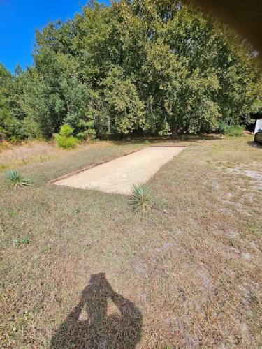 a shadow of a person standing in a field at la chêneraie appart Hérisson in Ychoux